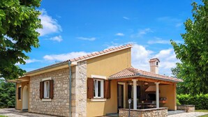 A two-story stone house with a tiled roof, a covered patio, and a stone pathway leading to the entrance. - Vacation home Ana by Interhome (Šibenik)