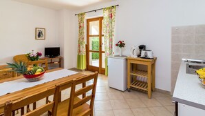 A compact kitchen with a dining area, a refrigerator, a coffee maker, and a toaster. - Villa Sand by Interhome (Poreč)