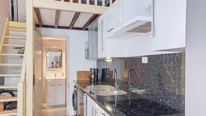 A compact kitchen with a built-in stove, a sink, and a washing machine. - Tiny Blue by Interhome (La Motte en Provence)
