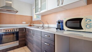 Eine moderne Küche mit Herd, Backofen, Mikrowelle und Schränken.