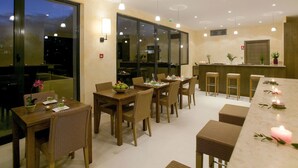 A dining area with multiple tables and chairs, a bar counter, and large windows. - Le Domaine de St. Endréol Golf & Spa by Interhome (La Motte en Provence)