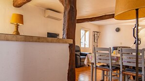 Ein Essbereich mit Holztisch und Stühlen, einer Lampe und einer Uhr an der Wand.