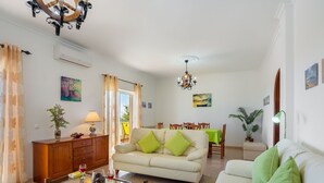 A living room with a sofa, coffee table, and dining area. - Paraíso by Interhome (Estoi)