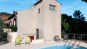 Un bâtiment doté d’une piscine, de chaises d’extérieur et surplombant un ciel dégagé.