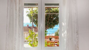 A window with a view of a terrace, potted plants, and a table. - Valentina by Interhome (Novi Vinodolski)