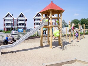 Kids can play on the playground's slide and climbing elements.