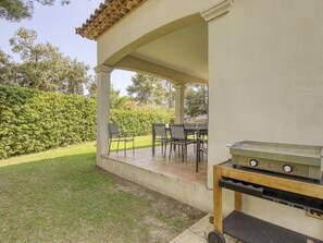 Relax in the serene outdoor patio, complete with a grill and comfortable seating for a leisurely meal.