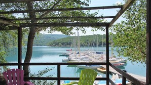 Un espace de repos abrité offrant une vue sur un lac et des bateaux.