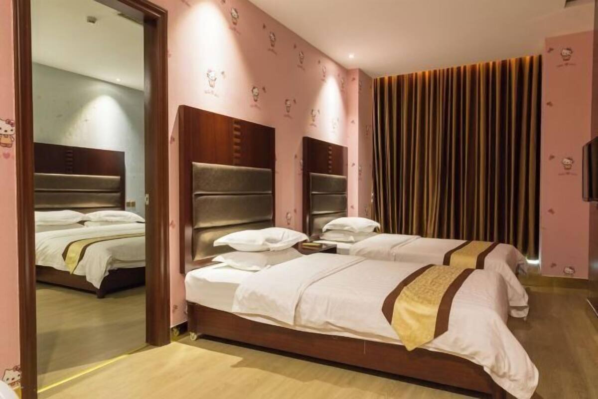 Ein Hotelzimmer mit zwei Betten, einem Holzkopfende, einem großen Spiegel und einem Vorhang.