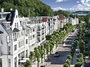 A row of white buildings with balconies and a cobblestone street lined with trees. - Stolzenfels by Interhome (Ostseebad Sellin)