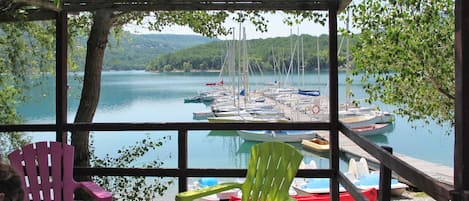 A covered seating area with a view of a lake and boats.