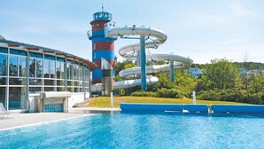 A water park with a tall tower, a large pool, and a building with large windows. - Seepark Sellin by Interhome (Ostseebad Sellin)