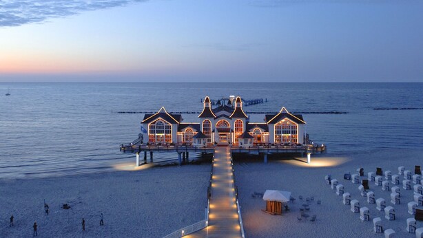 A seaside hotel with a long pier extending into the water, featuring multiple buildings with large windows and a central structure with a balcony. - Seepark Sellin by Interhome (Ostseebad Sellin)