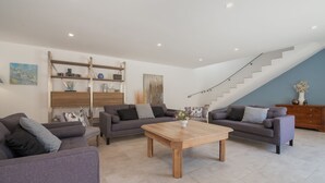 Ein modernes Wohnzimmer mit zwei Sofas, einem Couchtisch und einer Treppe.