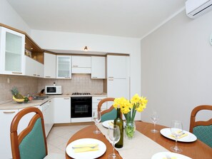 Enjoy meals in this fully equipped kitchen with a dining table, sink, and microwave.