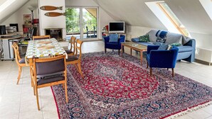 A spacious loft with a dining area, a sofa, and a TV. - Apartment Carola by Interhome (Godern)