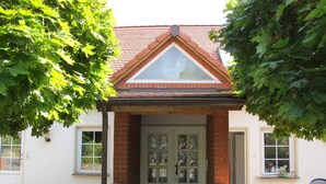 A house with a brick facade, a triangular roof, and a white door. - Apartment Carola by Interhome (Godern)