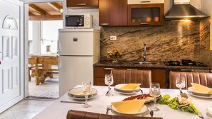 Eine moderne Küche mit Holzschränken, einer eingebauten Mikrowelle und einer Marmor-Spritzschutzwand.