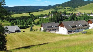 A rural village with traditional houses, a church, and rolling hills in the background. - Schwarzwaldblick III by Interhome (Bernau)