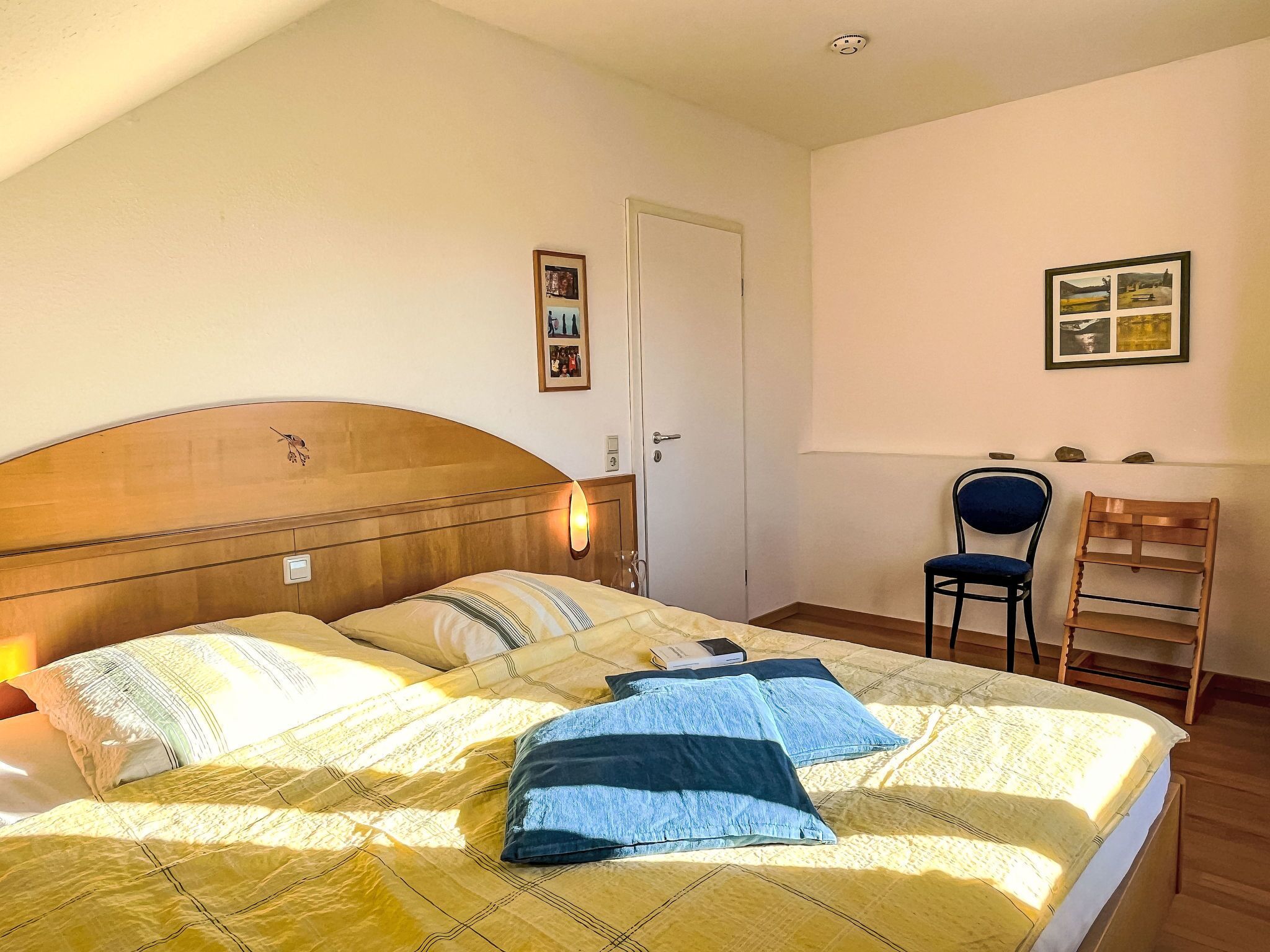 Une chambre à coucher avec un lit, une chaise, un bureau et une porte.