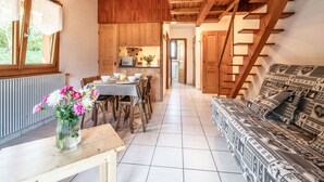 Un interno in legno con zona pranzo, divano e scala.