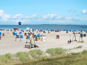 A beach with numerous colorful containers and a large blue balloon. - Sielmühle by Interhome (Dornumersiel)