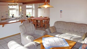 A living room with a sofa, two armchairs, a wooden coffee table, and a dining area with a table and chairs. - Altes Schöpfwerk by Interhome (Ditzum)