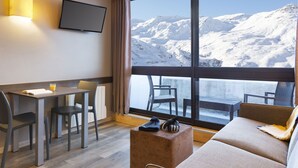 Ein modernes Hotelzimmer mit großem Fenster und Blick auf die Berge.