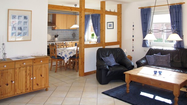 Un salon comprenant un canapé, une table basse et un coin repas avec une table et des chaises.