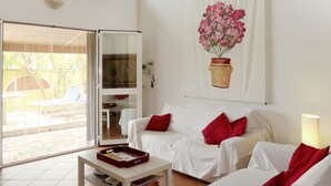 A living room with a white sofa set, a coffee table, and a sliding glass door leading to an outdoor area. - Villa Veranda by Interhome (Sanremo)