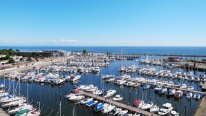 A marina with numerous boats docked, a clear sky, and a distant view of the sea. - Ostsee-Residenz (DMP153) by Interhome (Damp)