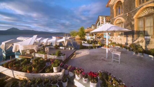 A coastal hotel patio with outdoor seating, potted plants, and a view of the sea. - Dieshu Private Holiday Villa (Lijiang)