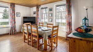 Ein Essbereich mit Holzzimmermöbeln, einem Fernseher und einem Tisch mit Unterlage.