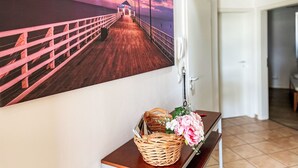 A hallway with a wooden bench, a wall-mounted telephone, and a framed picture of a pier. - Boddenzauber by Interhome (Breege)
