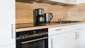 A modern kitchen with stainless steel appliances, wooden backsplash, and white cabinetry. - von Dollen by Interhome (Wingst)