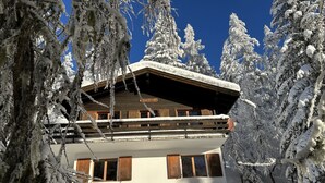 A snow-covered lodge with a wooden exterior and a balcony. - Chalet Soldanella (BEL205) by Interhome (Bellwald)