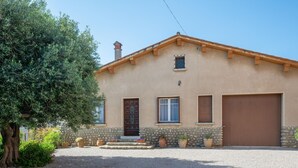 A two-story house with a stone facade, a wooden door, and a garage. - La Vigneronne by Interhome (Fourques)