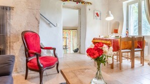 A cozy living room with a red velvet chair, a wooden coffee table, and a vase of flowers. - Chaud'abri by Interhome (Nyons)