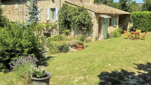 A stone house with a tiled roof, a small garden, and outdoor furniture. - Chaud'abri by Interhome (Nyons)