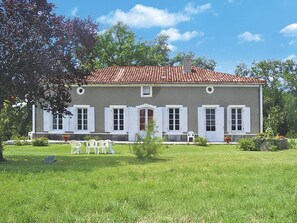 A two-story house with a red-tiled roof, white shutters, and a well-maintained lawn. - La Gaubide by Interhome (Castillonnes)