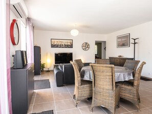 Relax in this stylish living room with a flat-screen TV, comfortable sofa, and dining area.