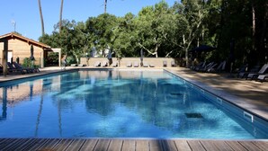 A swimming pool with lounge chairs and a wooden deck. - Premium Key West by Interhome (Ondres)
