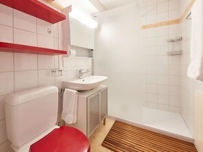 Un baño con inodoro, lavabo y ducha.