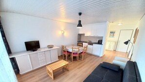 A compact living space with a kitchenette, a dining area, a sofa, and a television. - Essert 101 by Interhome (Thyon-Les Collons)