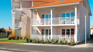 A two-story building with a red-tiled roof, white exterior, and a balcony with white railings. - Résidence Belle Dune by Interhome (Biscarrosse)