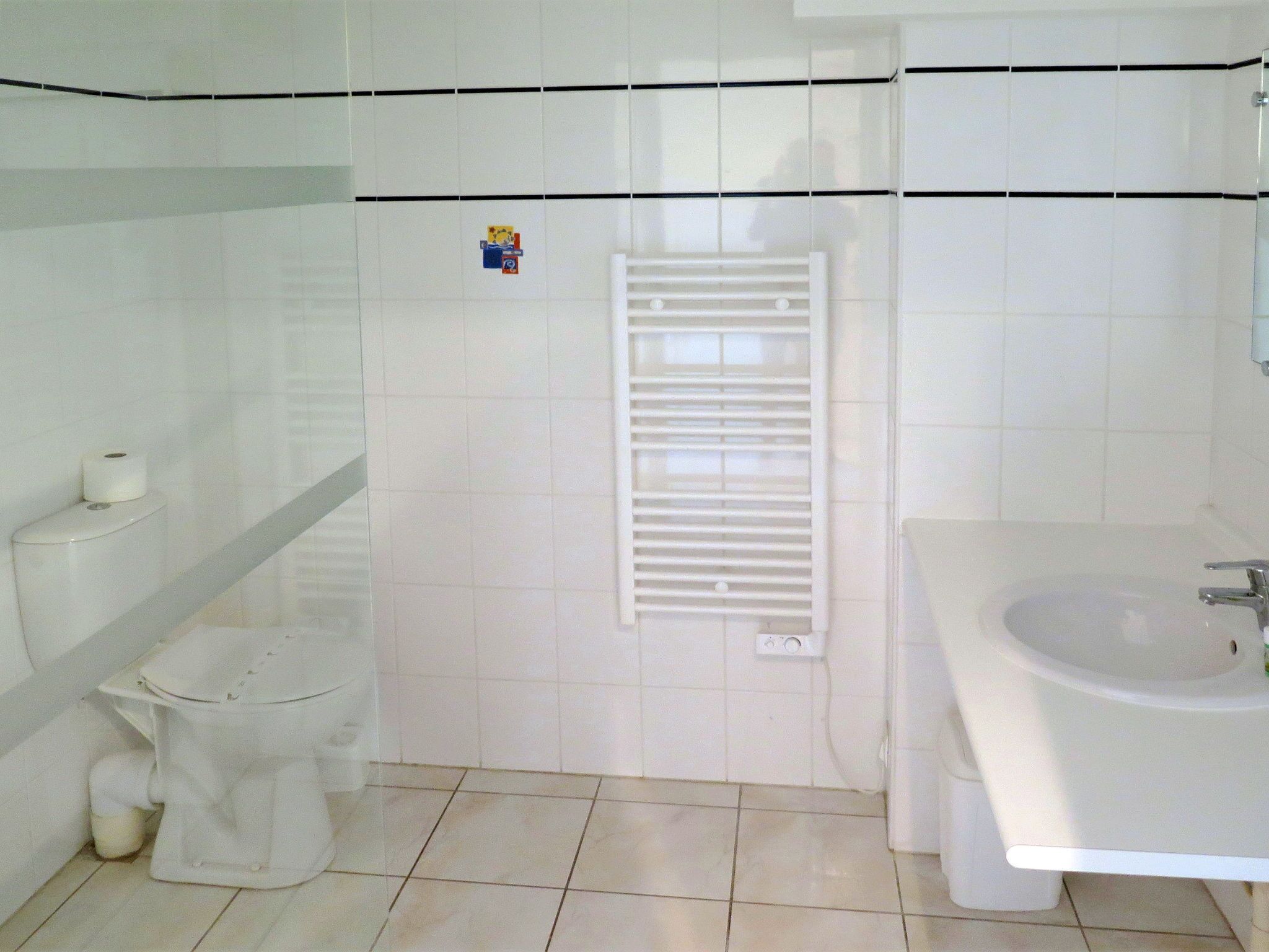Casa de banho com sanita, bidé e lavatório.