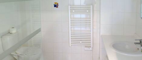 Casa de banho com sanita, bidé e lavatório.