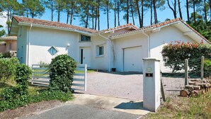 A two-story house with a tiled roof, a garage, and a driveway. - Le Moïsan by Interhome (Messanges)
