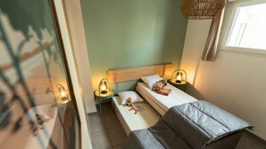 Ein Schlafzimmer mit einem Bett, zwei Nachttischen, einer Fensterbank, einem Fenster und einer Hängeleuchte.