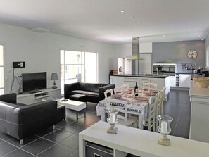 Relax in a spacious living area with a leather sofa and flat-screen TV, and enjoy meals at the dining table for four.